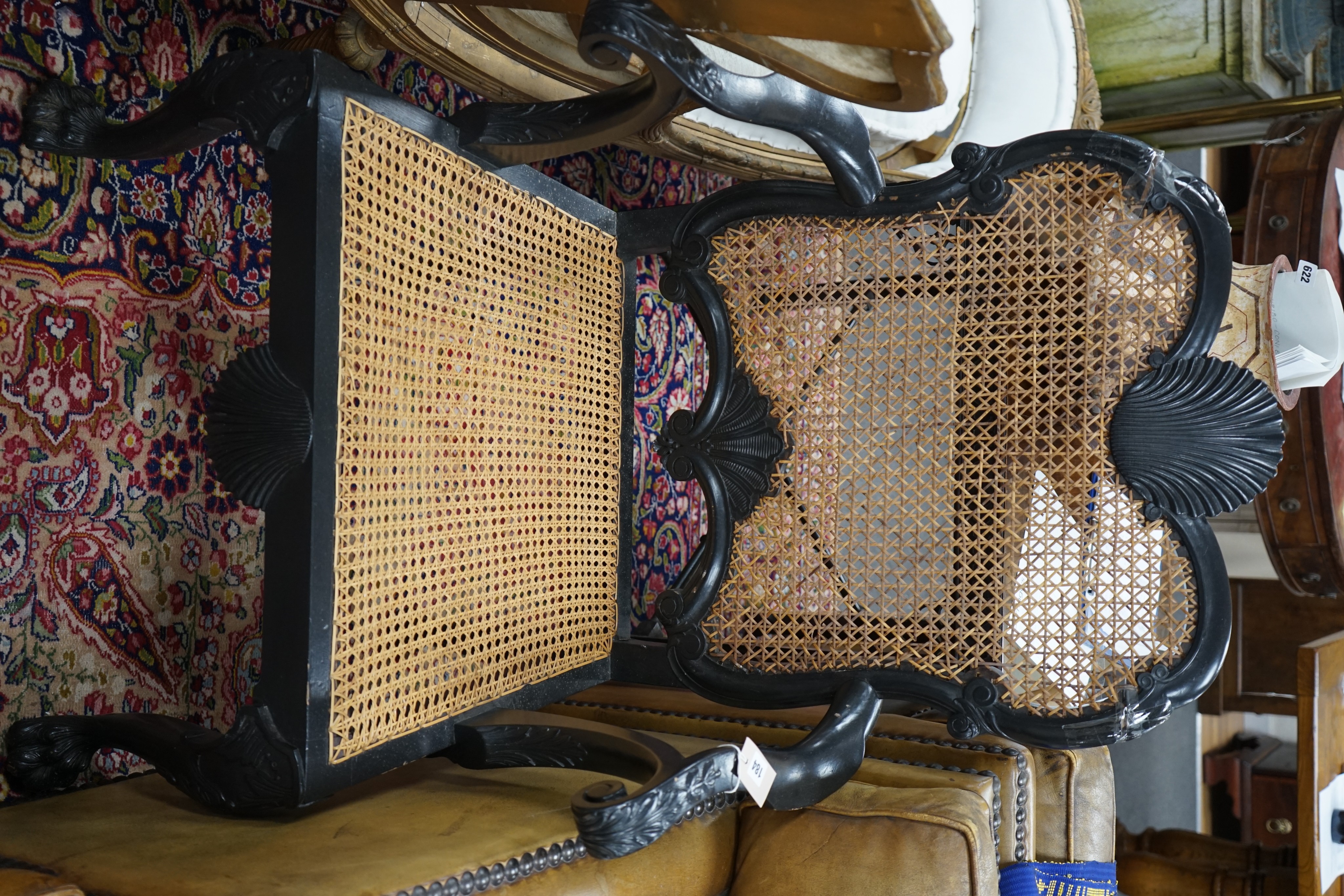An 18th century style ebonised caned Irish elbow chair, width 70cm, depth 46cm, height 107cm (top rail requires restoration)